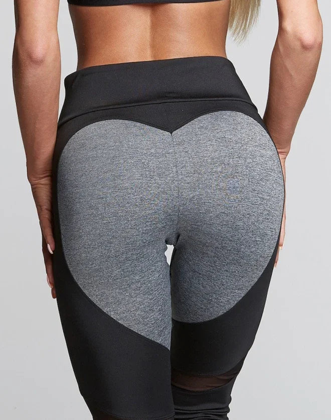 Close-up of woman wearing high-waisted black and gray heart pattern gym leggings fitness apparel