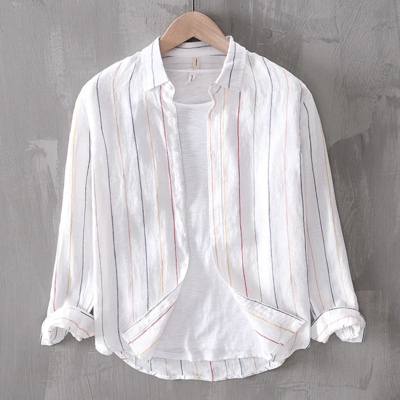 White long-sleeve button-up shirt with multicolor vertical stripes on wooden hanger against gray wall