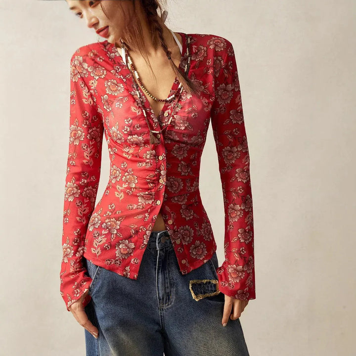 Woman wearing red floral print button-up blouse paired with blue denim jeans and layered necklaces