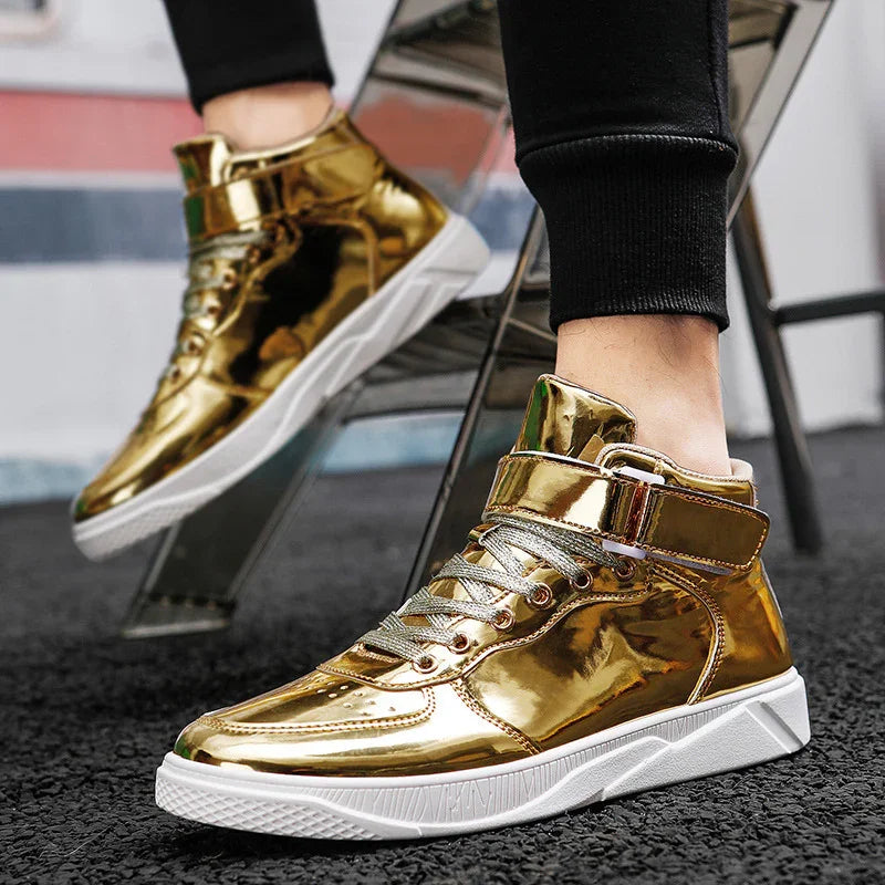 Close-up of shiny gold high-top sneakers with white soles worn with black pants