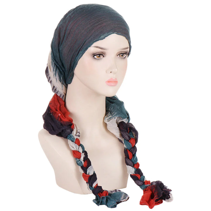 Mannequin wearing a multicolor braided turban scarf with shades of blue, red, black, and white