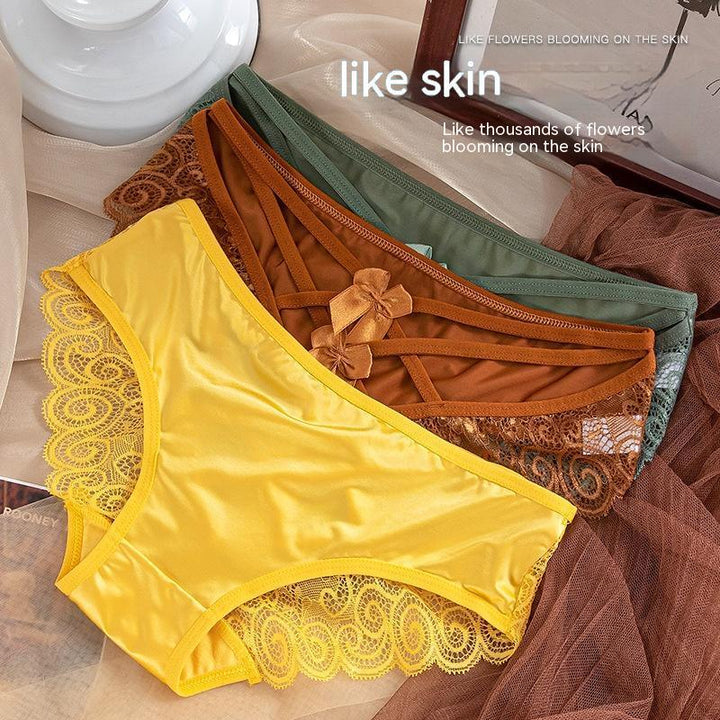 Close-up of four lace-trimmed silky women's panties in yellow, brown, green, and rust colors on fabric background