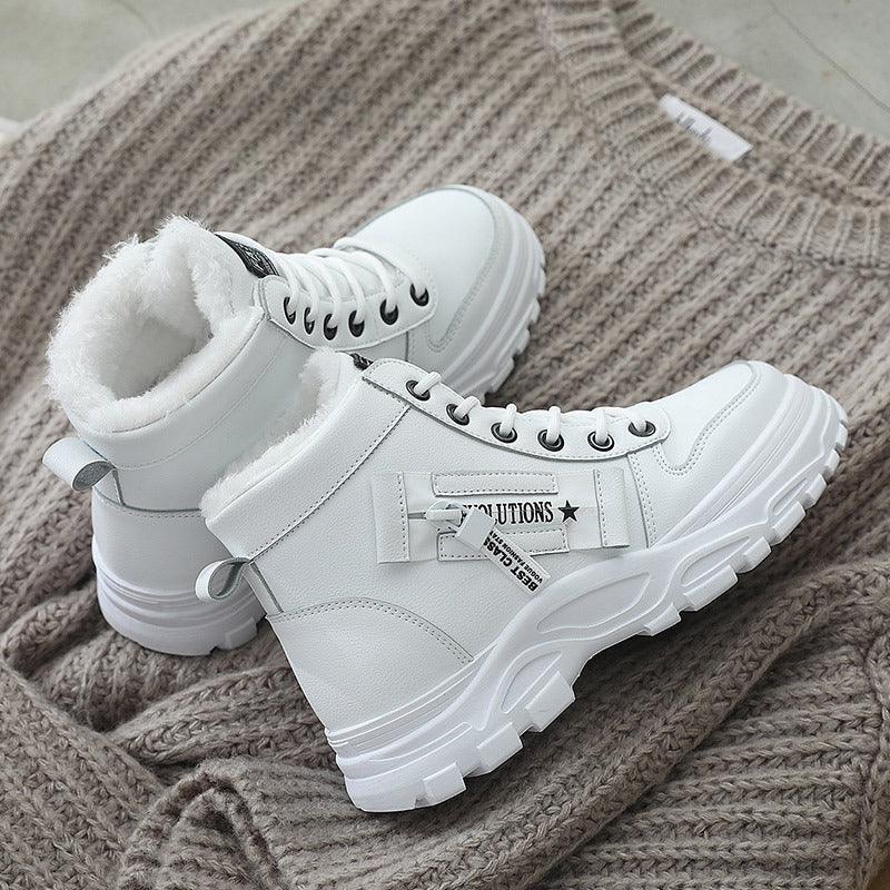 White winter boots with thick soles and fur lining on a knitted beige sweater