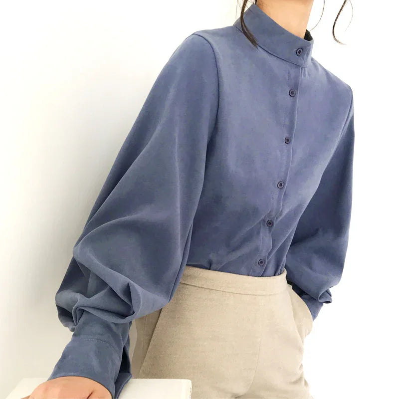 Blue button-up blouse with puffed long sleeves and beige high-waisted pants