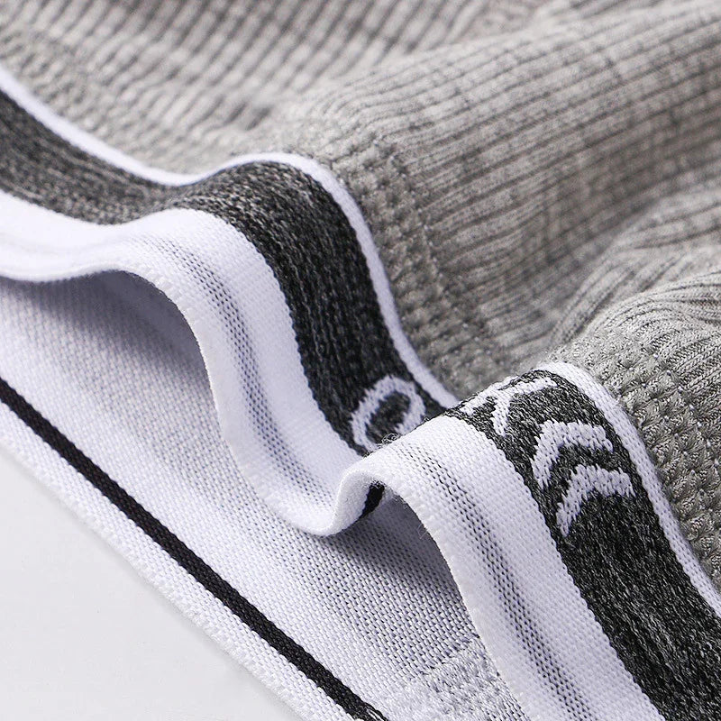Close-up of grey ribbed fabric with white and black elastic waistband featuring chevron pattern
