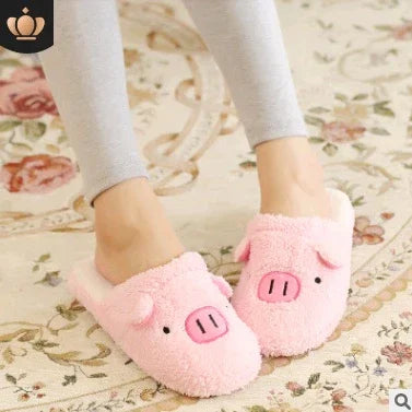 Person wearing cozy pink pig-themed slippers on a floral carpet