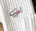 White ribbed fabric with small embroidered shark patch logo on pocket