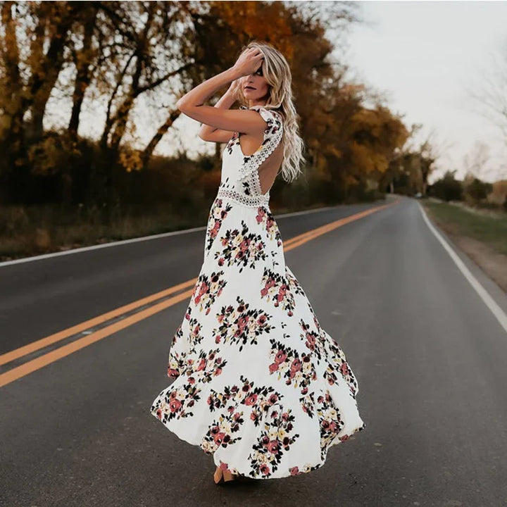 Woman wearing a white floral maxi dress with lace detail standing on an empty road during autumn