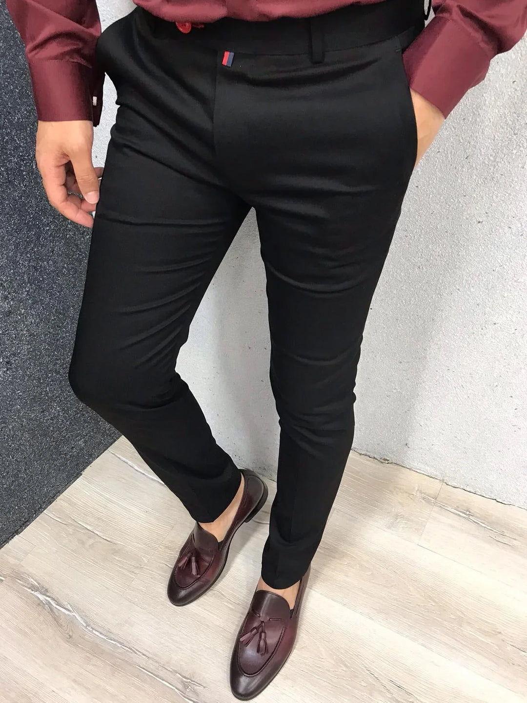 Man wearing slim fit black formal trousers paired with burgundy tassel loafers and matching shirt