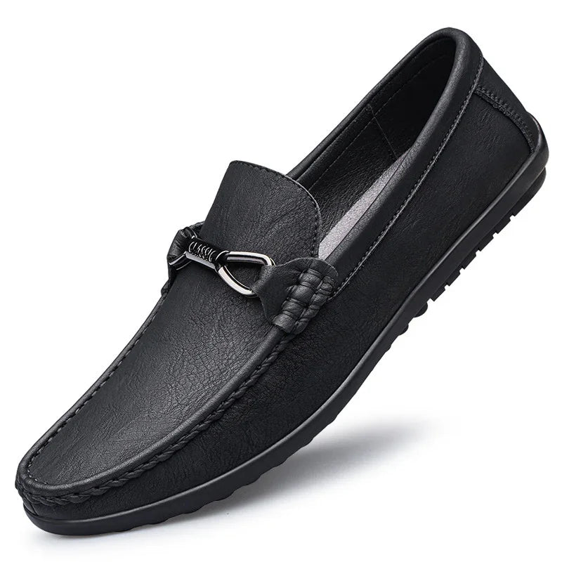 black leather men's loafer with metal bit detail and textured sole on white background