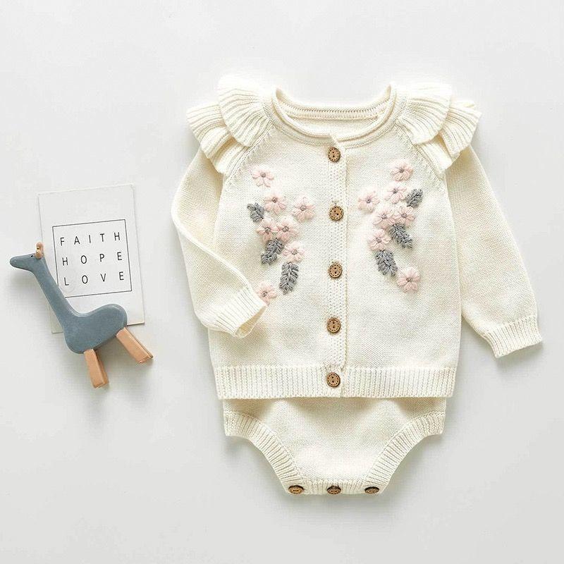 Cream-colored baby cardigan with floral embroidery and wooden buttons, paired with matching knit bottoms