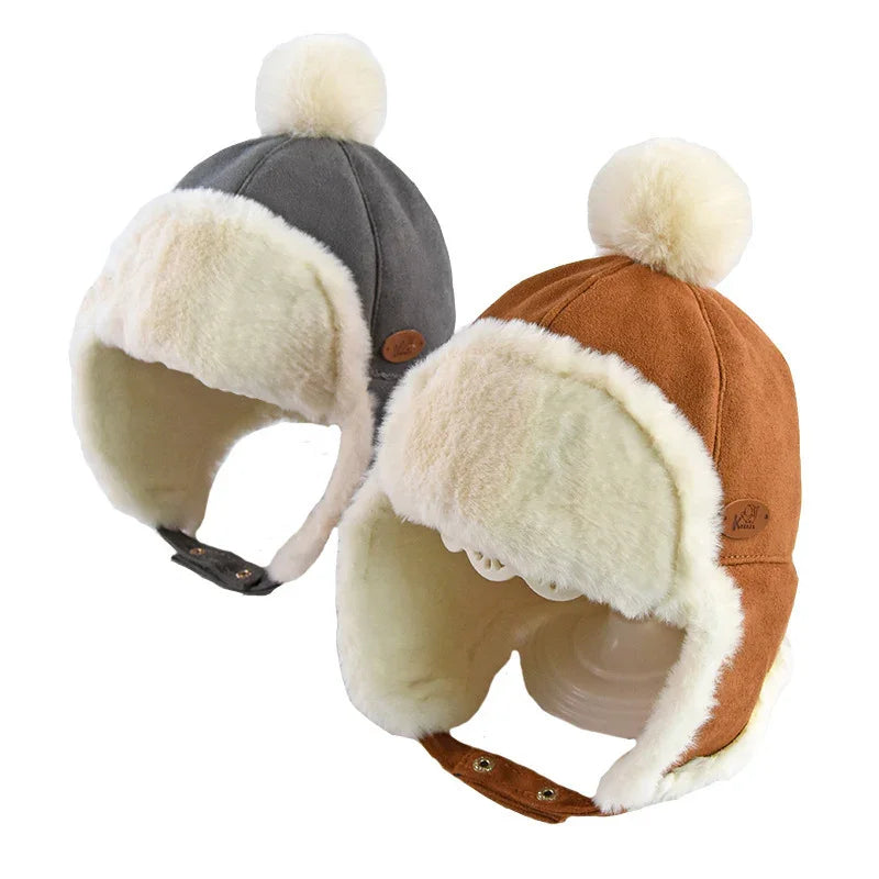 Two winter trapper hats with cream faux fur lining and pom-poms, one gray and one brown