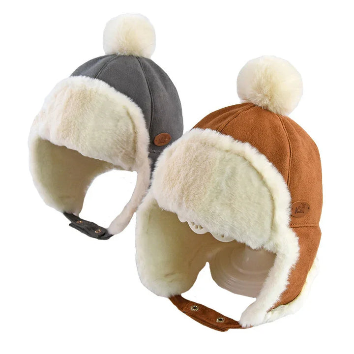 Two winter trapper hats with cream faux fur lining and pom-poms, one gray and one brown