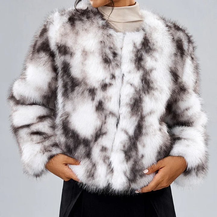 Woman wearing white and black spotted faux fur coat with hands in pockets