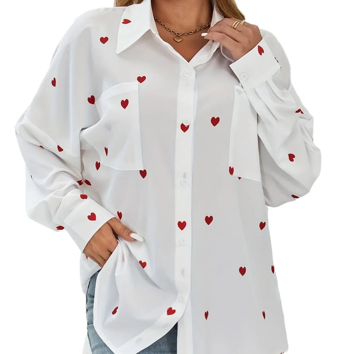 White button-up shirt with red heart pattern, worn with jeans and gold necklace