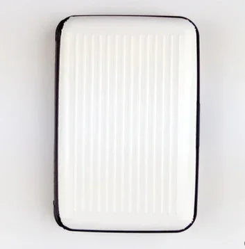 White rectangular grill pan with black rim on white background, vertical ridges, modern kitchenware