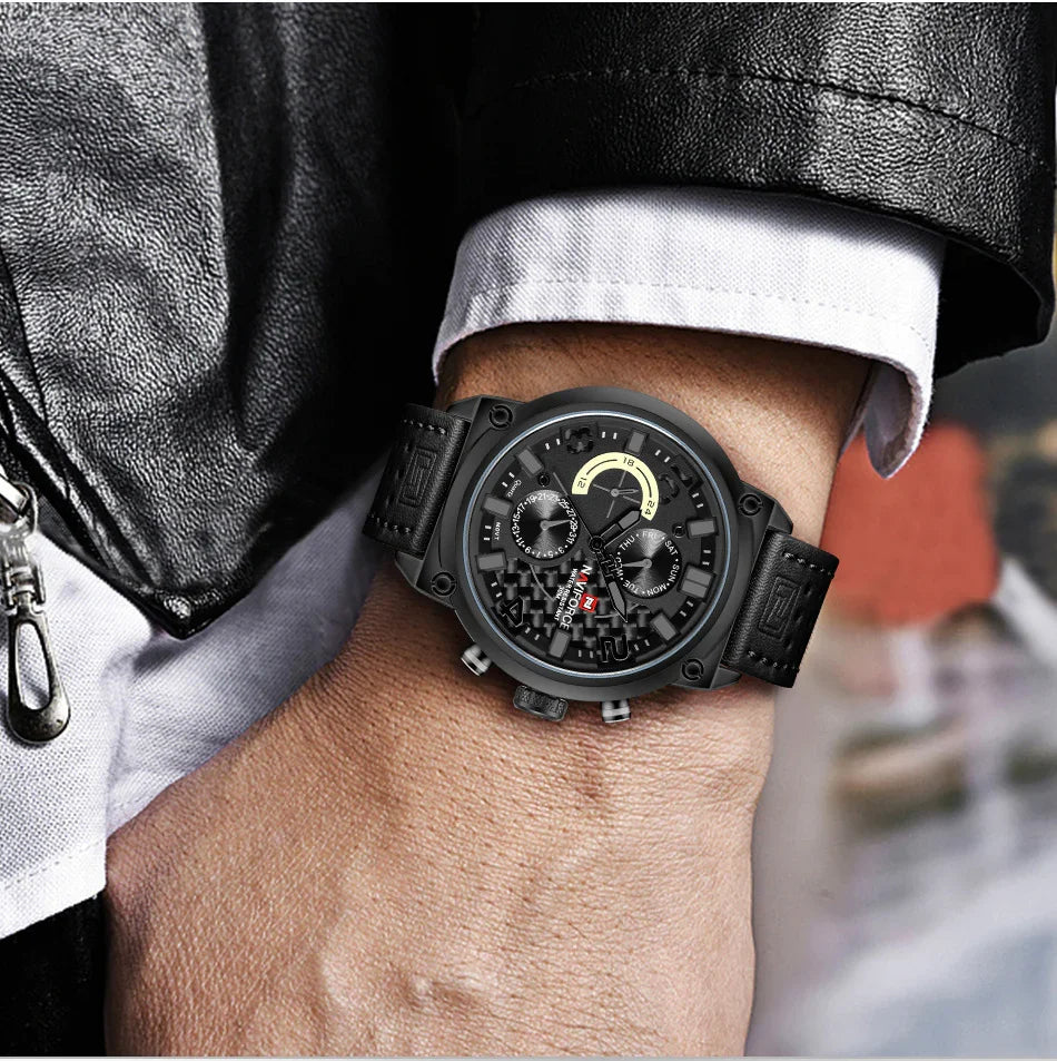 Close-up of a person's wrist wearing a black leather strap wristwatch with a multi-function black dial and white shirt cuff.