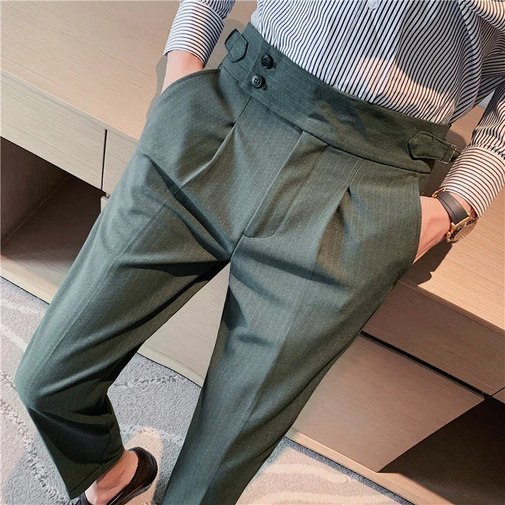 Person wearing olive green high-waisted pleated trousers with a double button detail and striped shirt