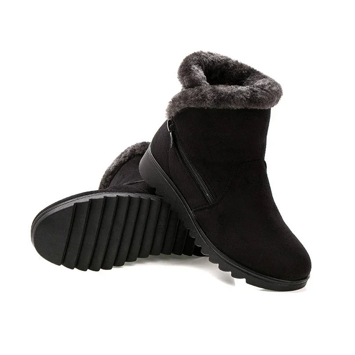Black winter boots with faux fur lining and side zipper on white background