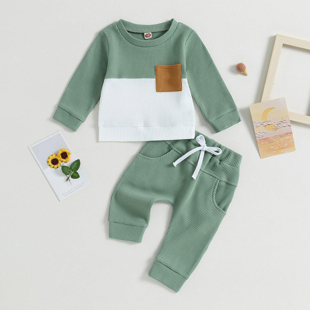 Two-piece toddler outfit with green and white waffle knit fabric, brown chest pocket, and matching green pants with white drawstring