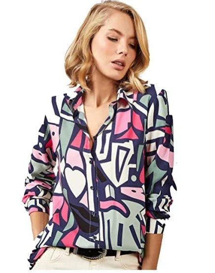 Woman wearing a colorful abstract print button-up shirt with white pants and a black belt