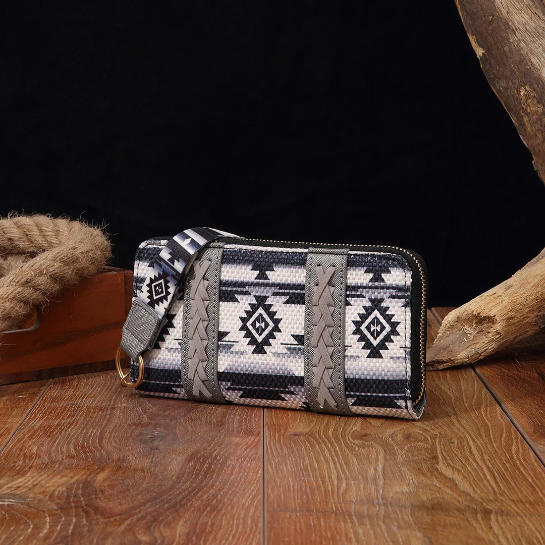 Black and white tribal pattern zip-around wallet with braided details on wood surface