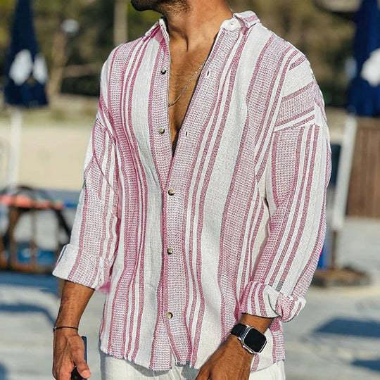 Man wearing casual white and red striped button-up shirt with rolled sleeves and smartwatch outdoors