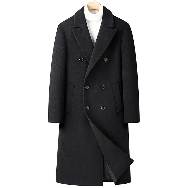 Black double-breasted wool coat with notch lapels on wooden hanger over white turtleneck sweater