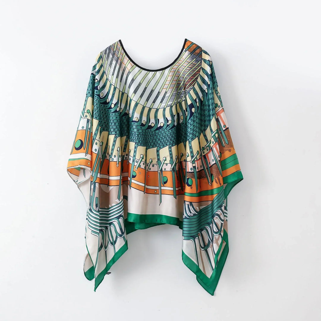 Colorful bohemian style poncho with geometric and abstract patterns in green, orange, and beige