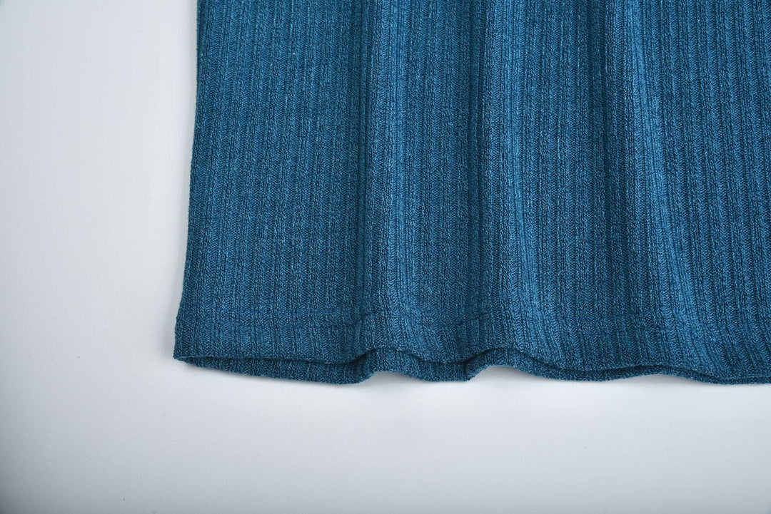 Close-up of blue ribbed knit fabric garment hem on white background