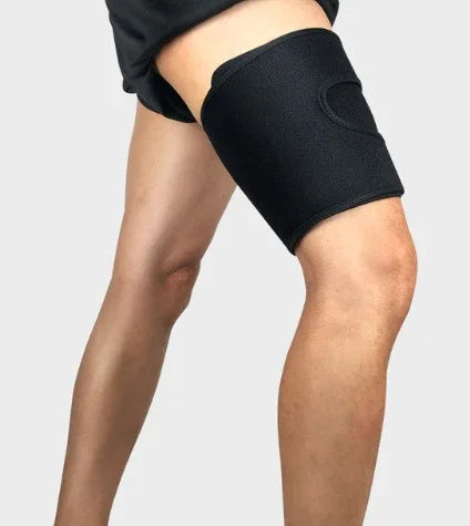 Person wearing a black thigh compression sleeve for support and muscle recovery