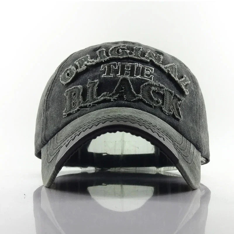 Faded black distressed baseball cap with embroidered text 'ORIGINAL THE BLACK' on front