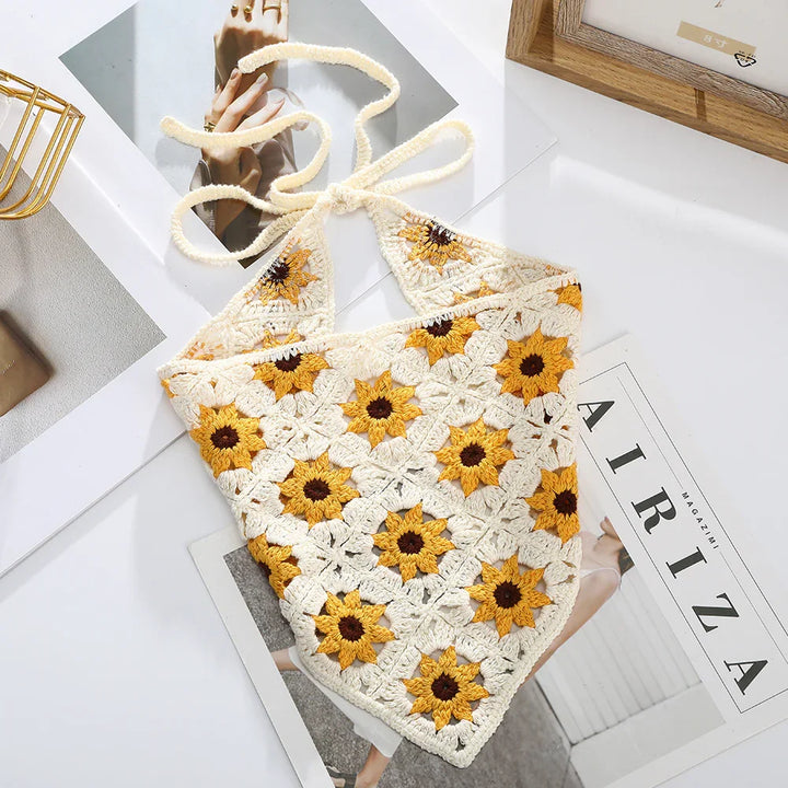 Cream crochet halter top with yellow sunflower patterns on magazine and photo backdrop