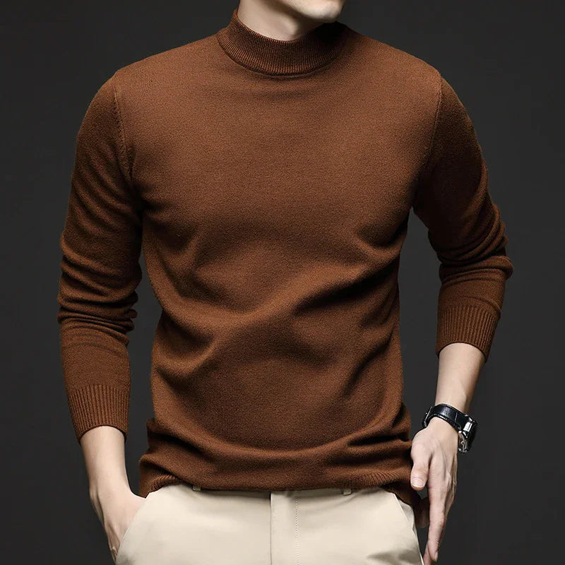 Man wearing a brown turtleneck sweater with beige pants and a black wristwatch
