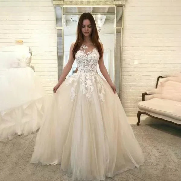 Bride wearing elegant lace bodice and tulle ball gown wedding dress in bridal boutique