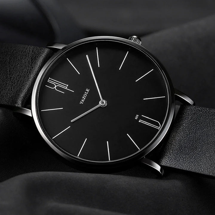 Minimalist black Yazole wristwatch with silver hands and black leather strap on black fabric