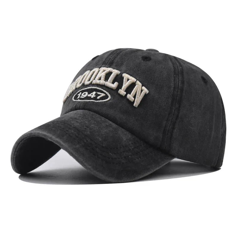 Black distressed baseball cap with cream embroidered text Brooklyn 1947 on front
