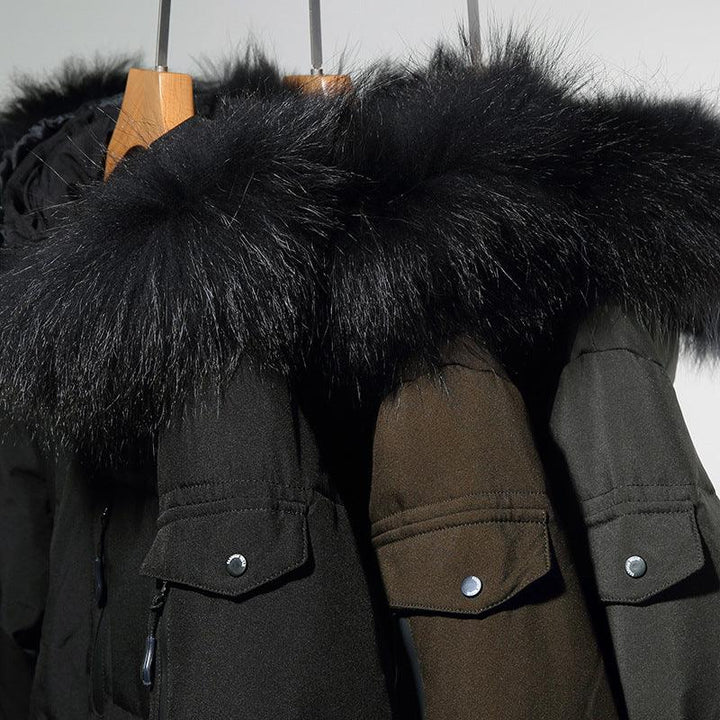 Black and brown winter coats with large black fur collars hanging on wooden hangers