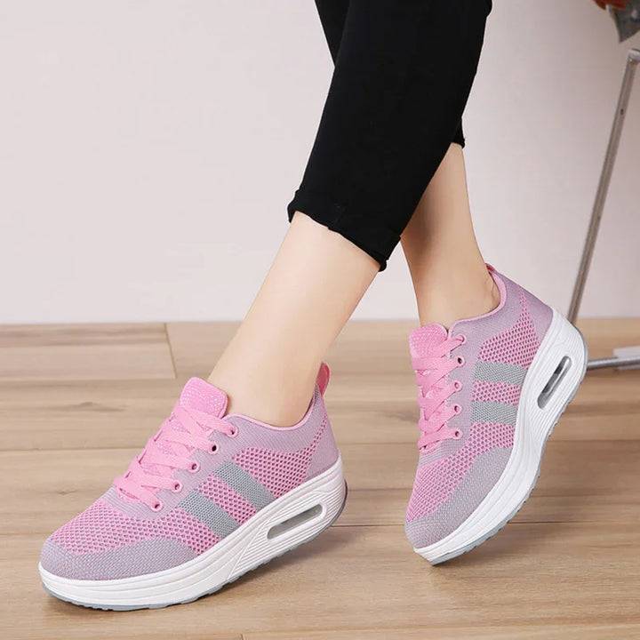 Pink and gray women's breathable mesh sneakers with white thick sole on wooden floor