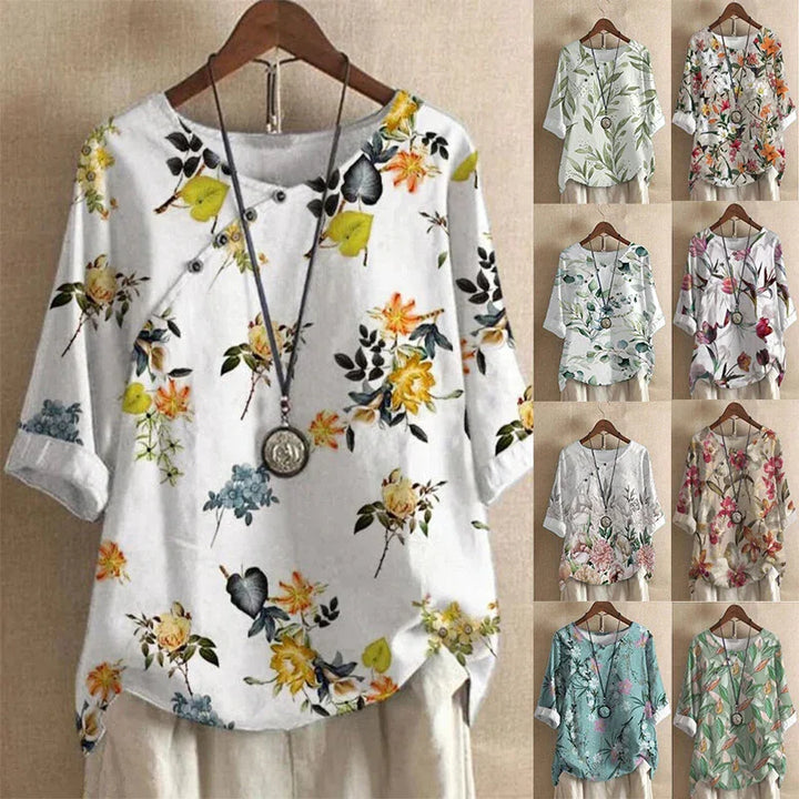 Floral print casual women's shirts in various colors with round neck and necklace, displayed on wooden hangers