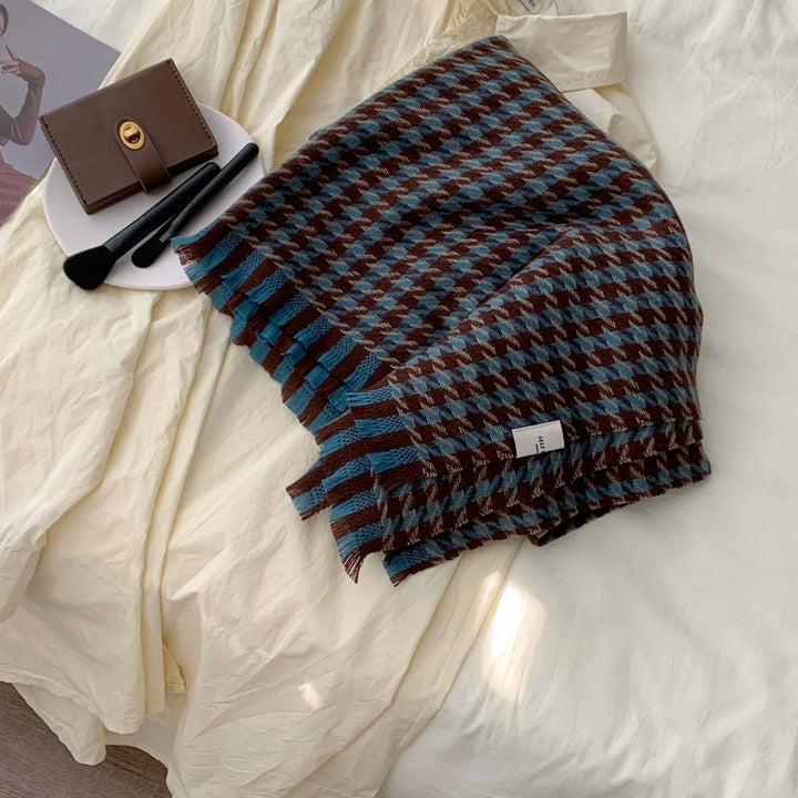 Blue and brown houndstooth wool scarf with fringes on cream fabric background