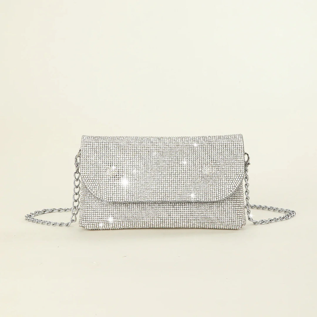 Silver rhinestone mesh clutch purse with chain strap on off-white background