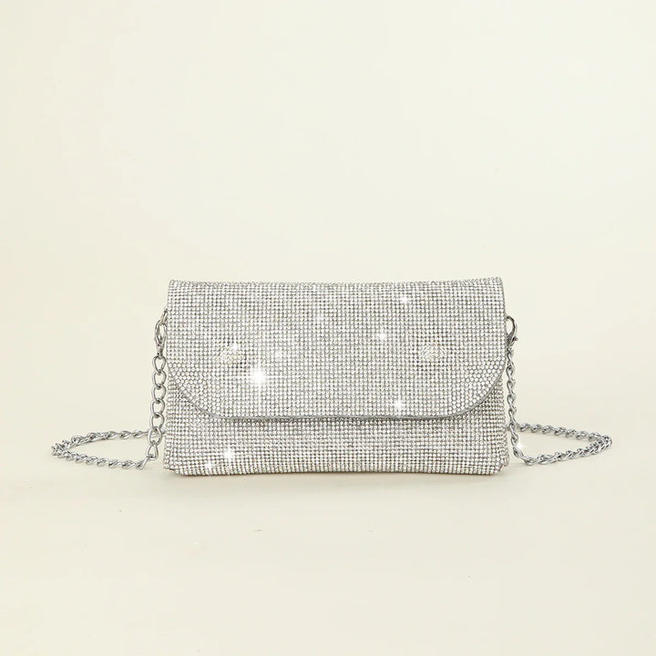 Silver rhinestone mesh clutch purse with chain strap on off-white background