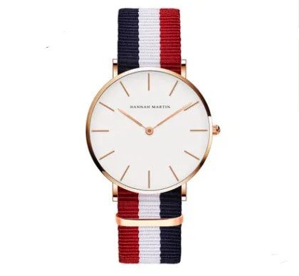 Minimalist watch with rose gold case, white dial, and red, white, blue striped nylon strap