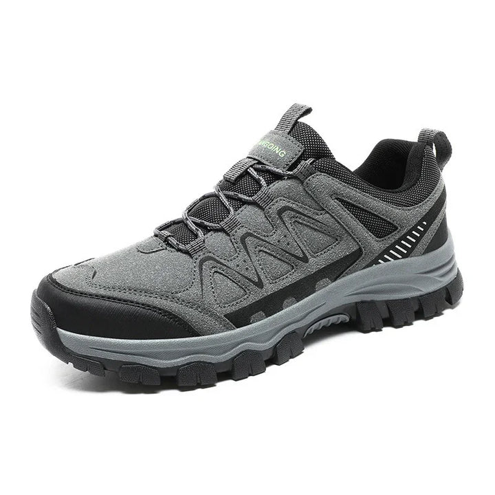 Gray and black hiking shoe with rugged sole and synthetic mesh upper on white background