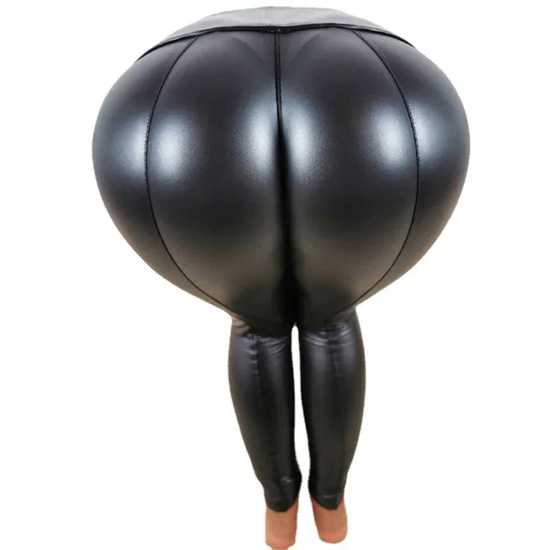 Black shiny faux leather high-waisted leggings with exaggerated padded hips, worn on feet