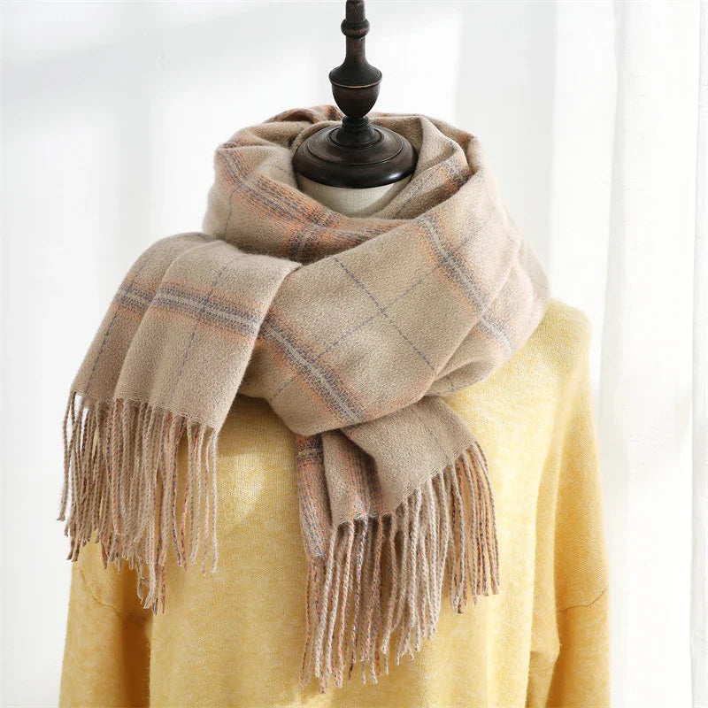 Beige plaid wool scarf with fringes on a mannequin wearing a yellow sweater in soft light