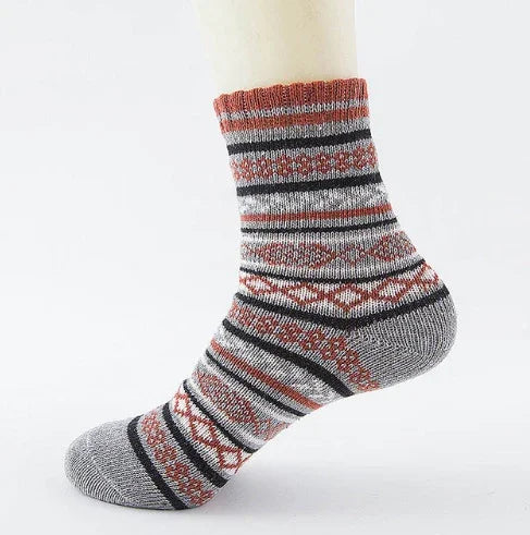 Cozy wool sock with red, black, and gray geometric patterns on a mannequin foot
