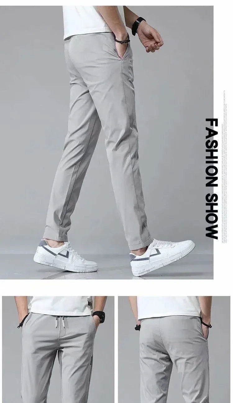 Men's light gray casual pants paired with white sneakers in a fashion show setting