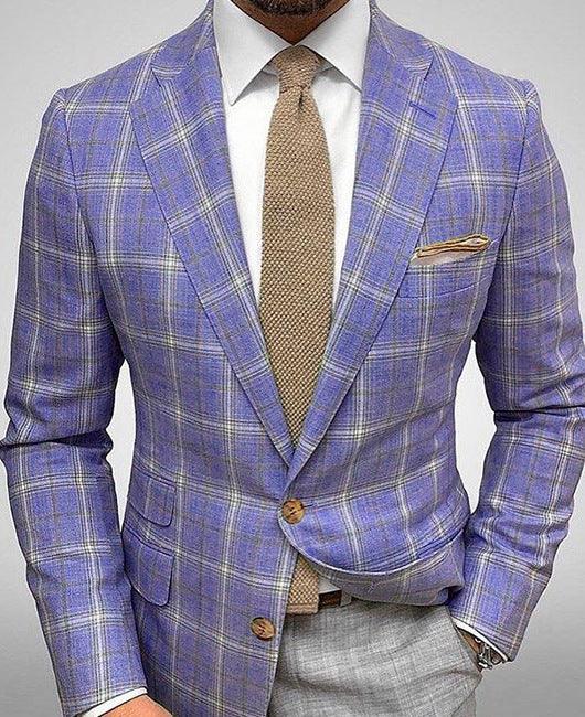 Man wearing a purple plaid blazer with tan knit tie and beige pocket square over white shirt